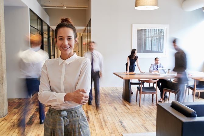 employee smiling in busy modern office