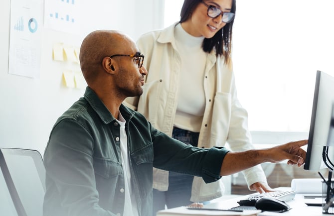 male and female coworkers conversing over computer screen